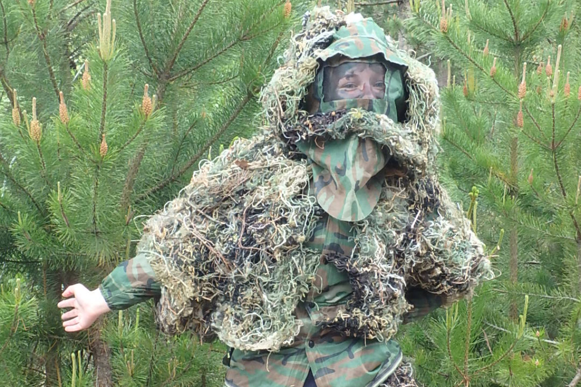 a young person in camouflage as as part of a bushcraft - manhunt session
