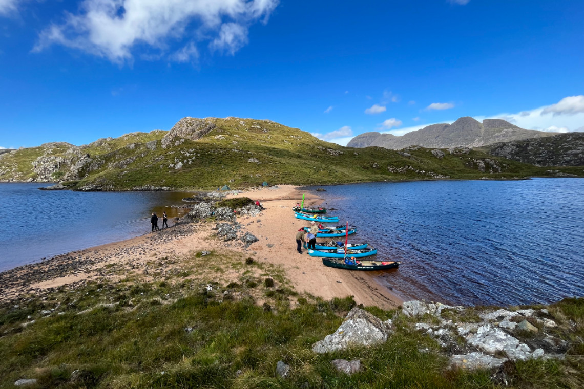 canoes landed on a remote beach on a highland loch in the inverpolly area of scotland