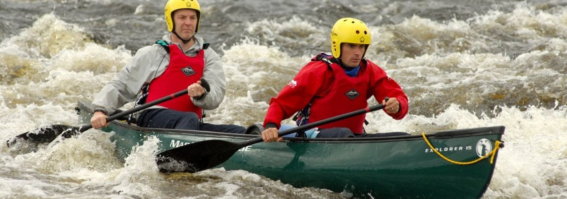 2 men canoeing 'the washing machine' rapids on river spey