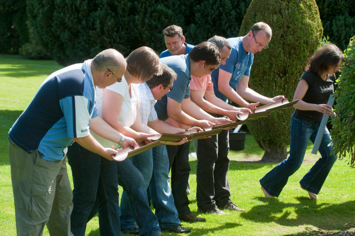 A group of work colleagues workign together to undertake a team challenge