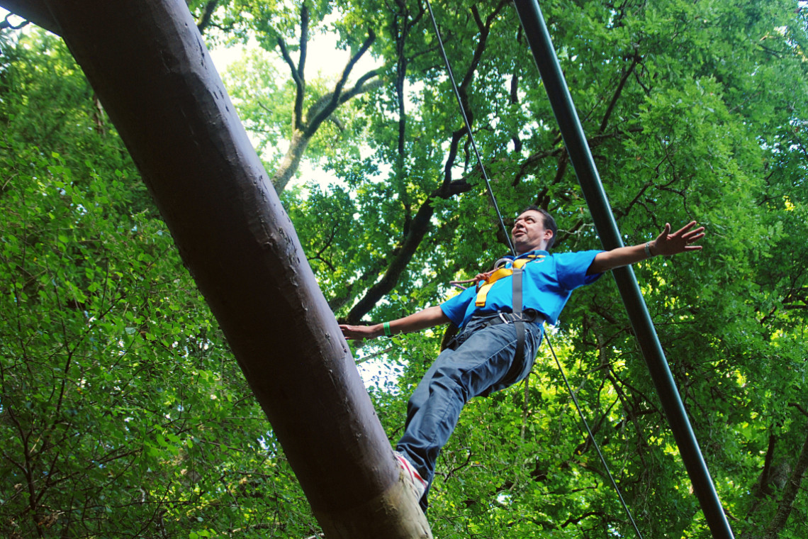 young person on a log balance beam while at treezone treetop adventure course