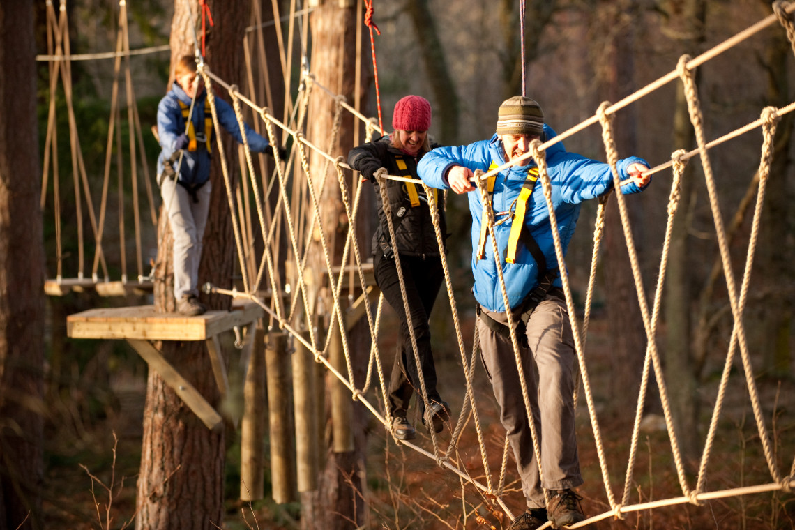 a man and women on a rope bridge at treezone aviemore